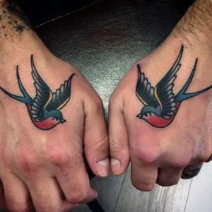 Traditional Swallow tattoos on the back of a man's hands