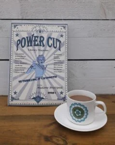 Power Cut Literary Magazine with a white and floral coffee cup